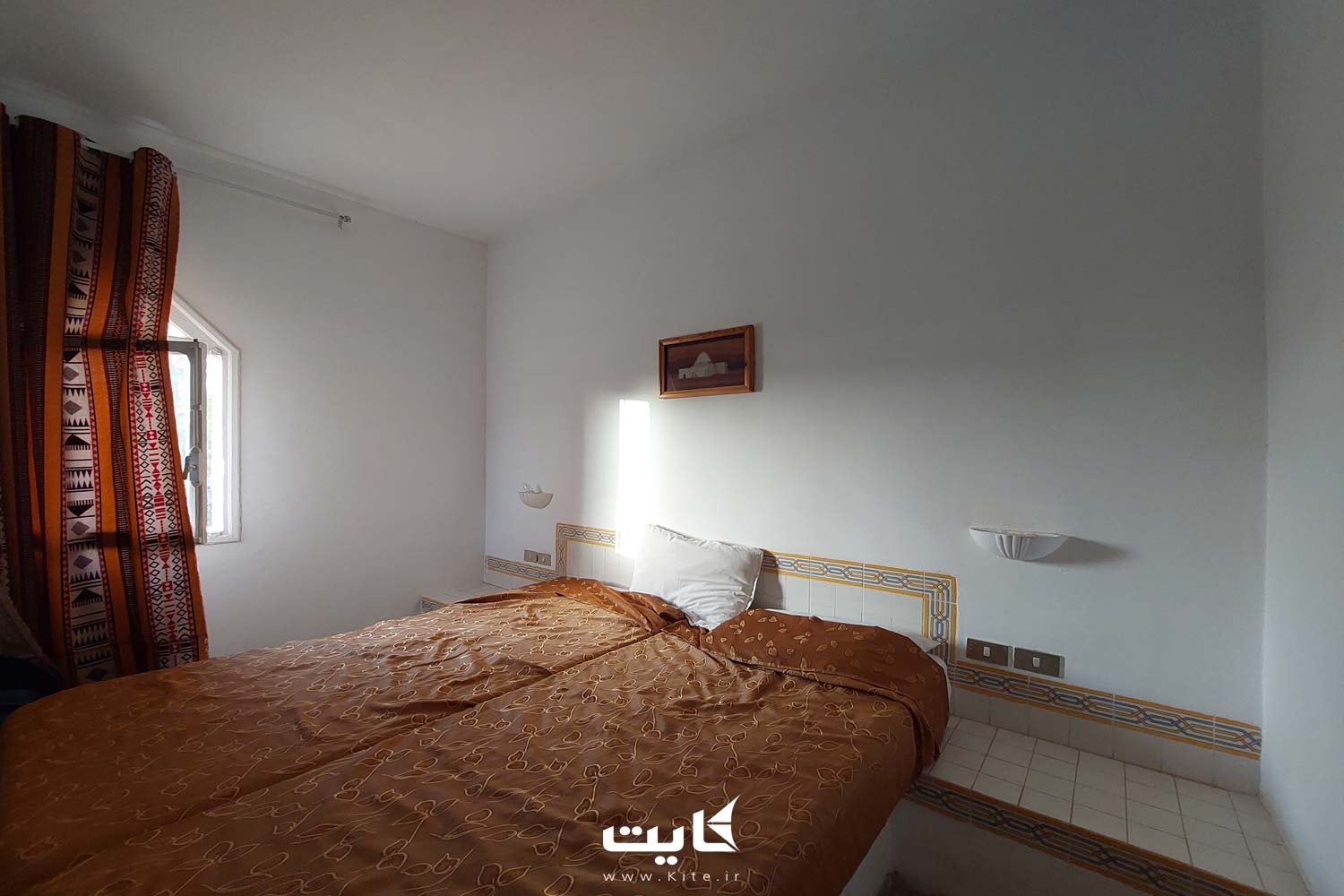 یک اتاق ساده با دیوارهای سفید و یک تخت