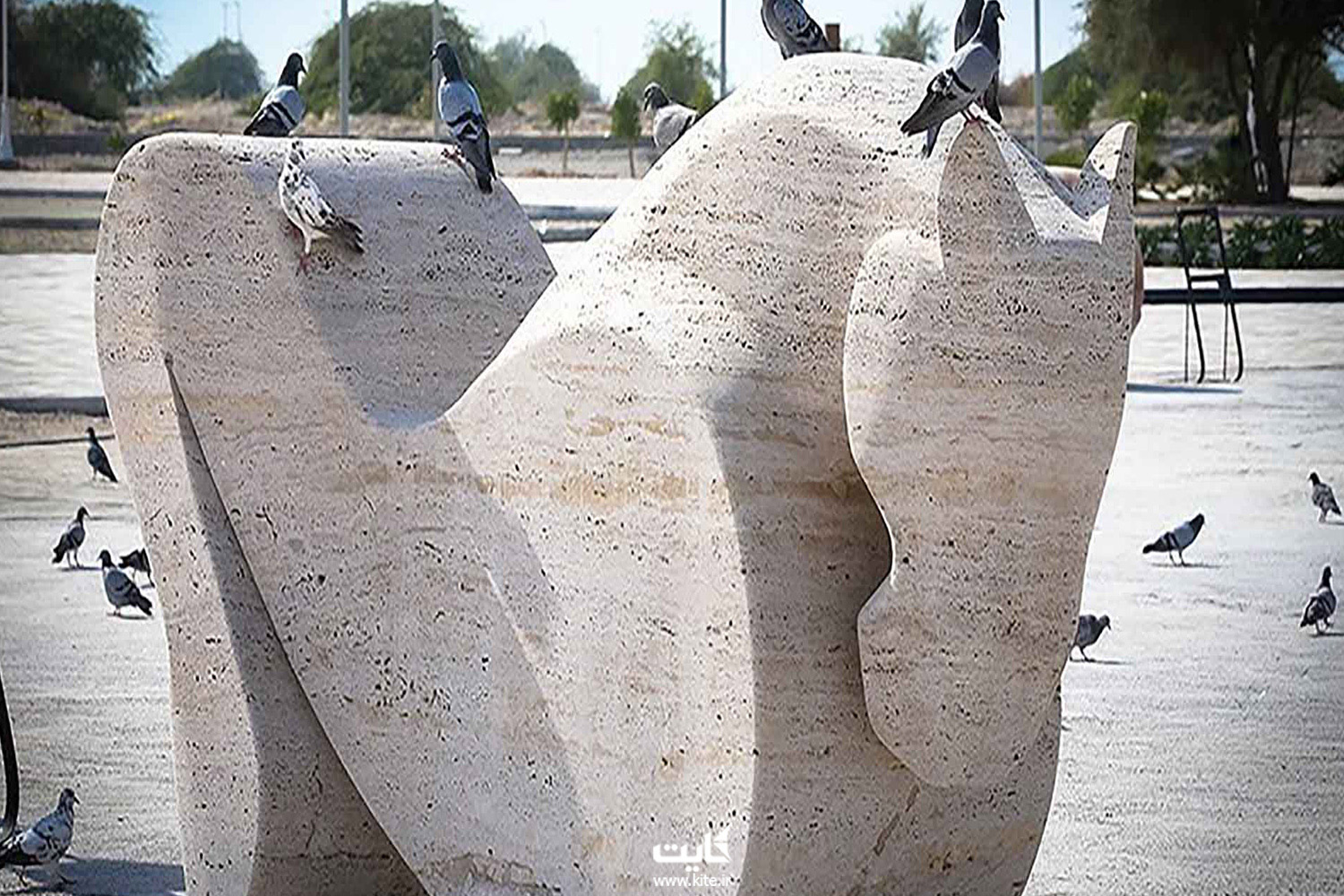 چند پرنده روی یک مجسمه‌ی سنگی نشسته‌اند