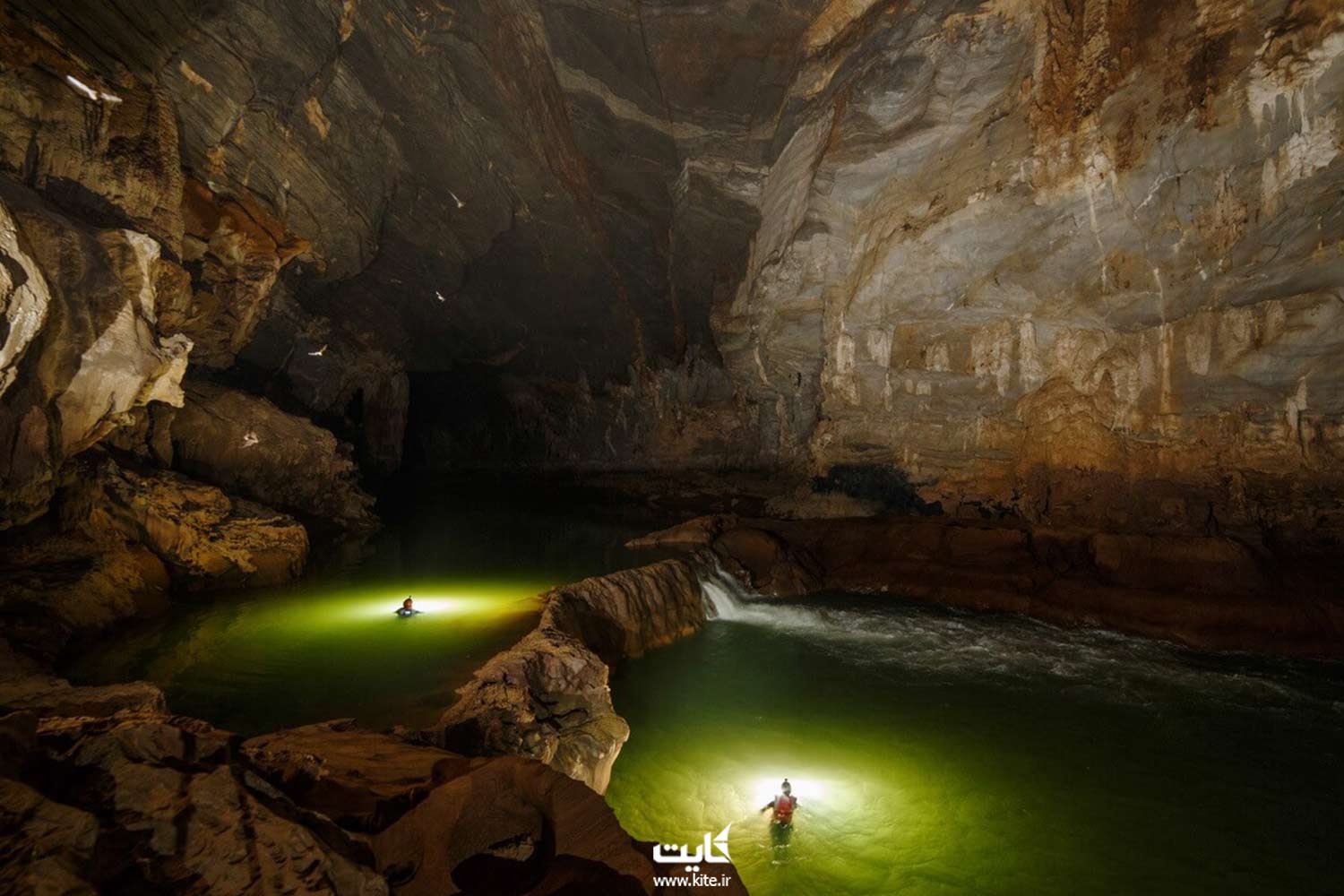 دو مرد در حال شنا داخل حوضچه های یک غار