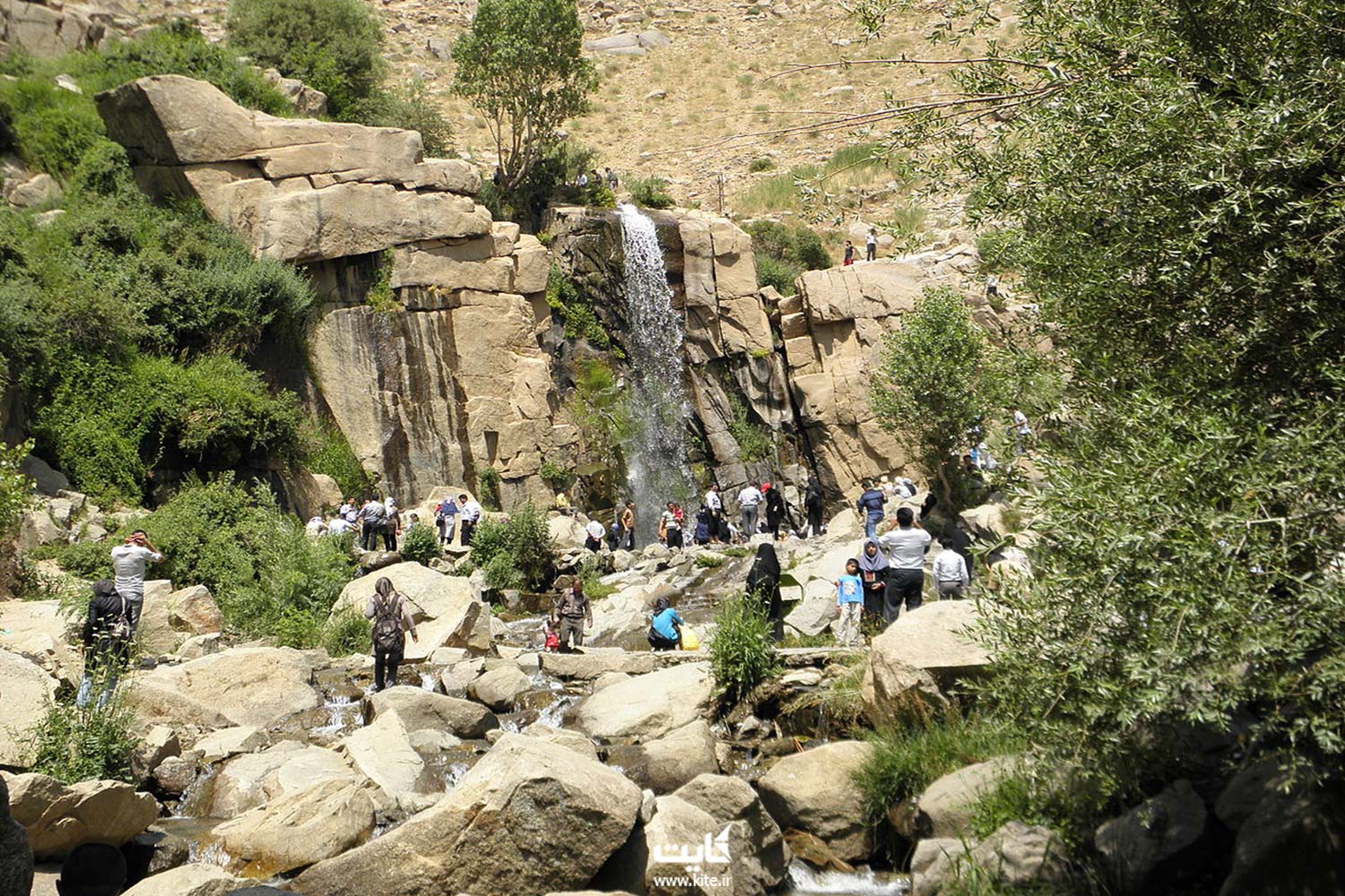 یک آبشار بزرگ صخره های سنگی و چندین گردشگر